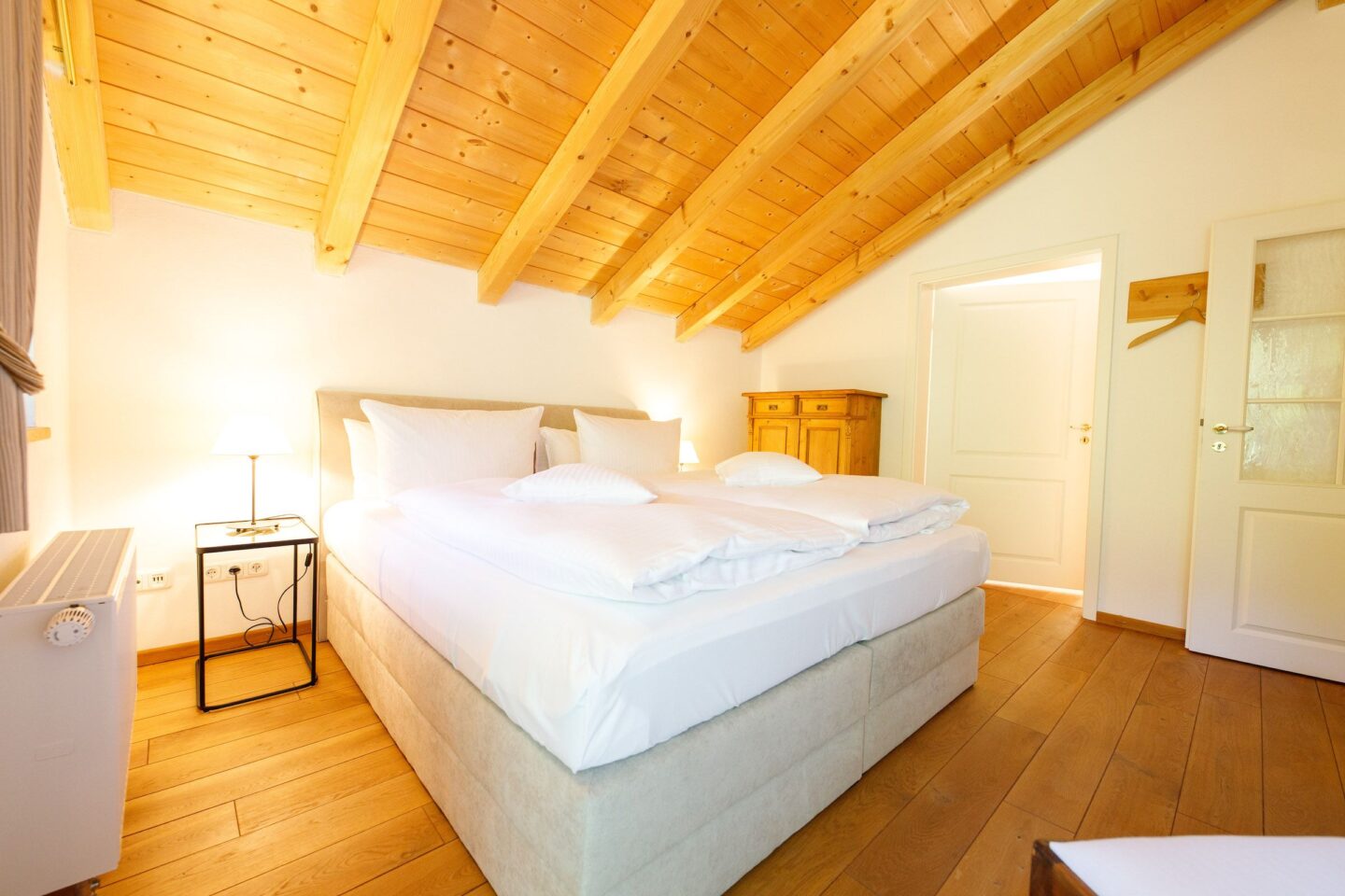 Doppelbett unter einer Dachschräge in Ferienwohnung in Garmisch-Partenkirchen