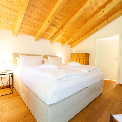 Doppelbett unter einer Dachschräge in Ferienwohnung in Garmisch-Partenkirchen