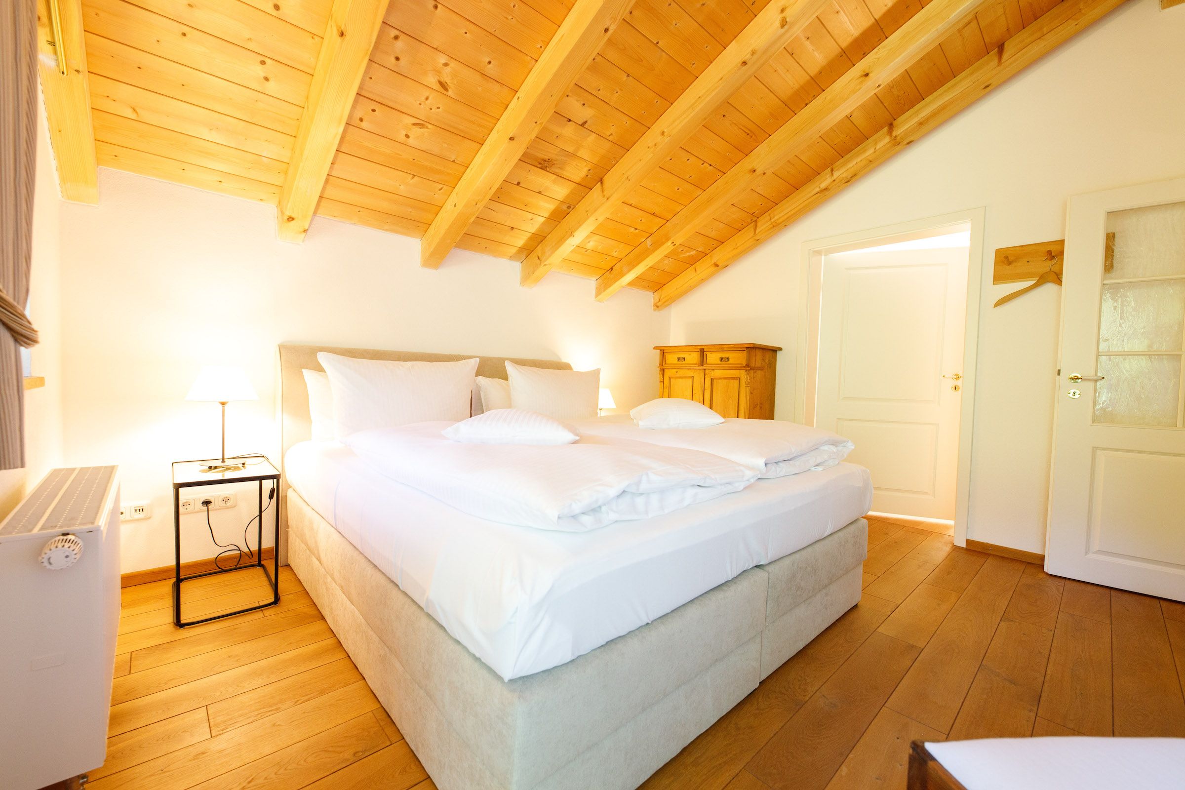 Doppelbett unter einer Dachschräge in Ferienwohnung in Garmisch-Partenkirchen