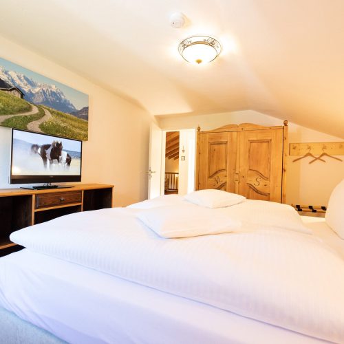 Doppelbett mit Fernseher in Ferienwohnung in Garmisch-Partenkirchen