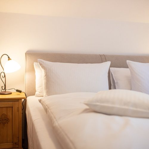 Doppelbett mit Nachttischlampe in Ferienwohnung in Garmisch-Partenkirchen