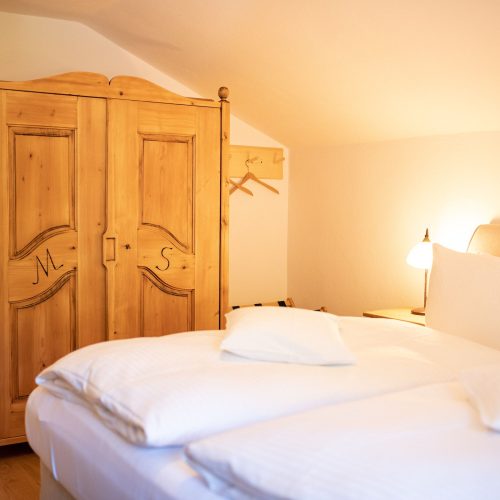 Doppelbett im Schlafzimmer mit Kleiderschrank in Ferienwohnung in Garmisch-Partenkirchen