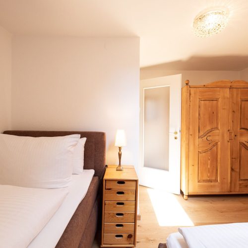 Schlafzimmer mit Schrank und Nachttisch in Ferienwohnung in Garmisch-Partenkirchen