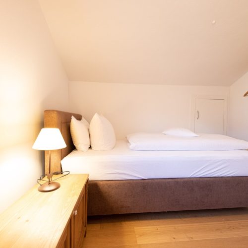 Einzelbett mit Lampe in Ferienwohnung in Garmisch-Partenkirchen