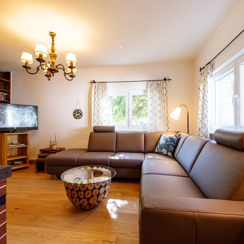 Wohnzimmer mit Sofa und Fernseher in Ferienwohnung in Garmisch-Partenkirchen