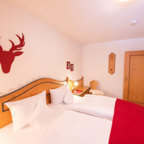 Doppelbettzimmer mit rotem Hirsch Umriss in Ferienwohnung in Garmisch-Partenkirchen