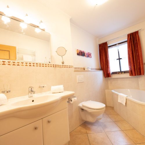 Badezimmer mit Waschbecken und Badewanne in Ferienwohnung in Garmisch-Partenkirchen