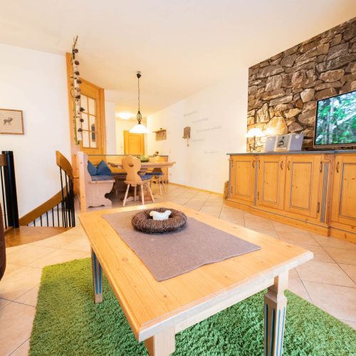 Fernseher mit Sofa und Tisch in Ferienwohnung in Garmisch-Partenkirchen