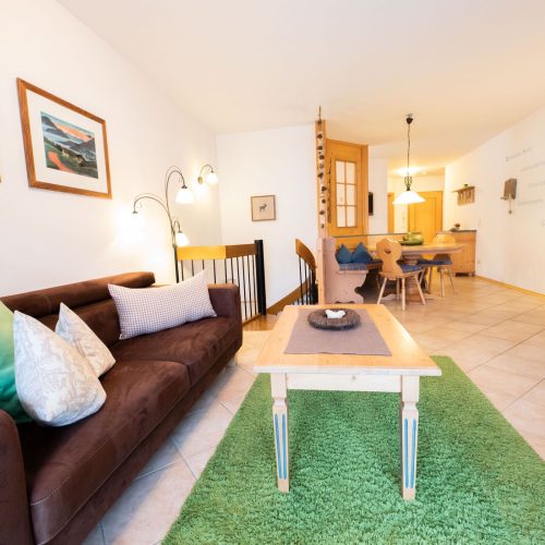 Sofa mit grünem Teppich in Ferienwohnung in Garmisch-Partenkirchen