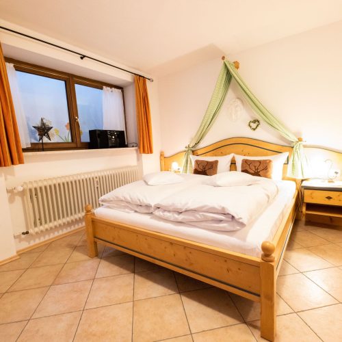 Doppelbett mit Nachttisch in Ferienwohnung in Garmisch-Partenkirchen