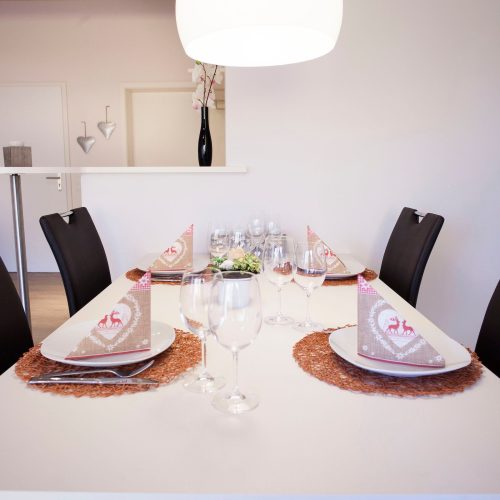 Esszimmer mit einer Stehlampe und gedecktem Tisch in Ferienwohnung in Garmisch-Partenkirchen