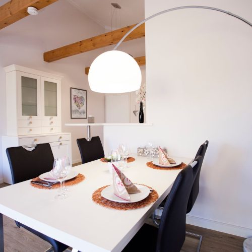 Stehlampe im Essbereich und eine weiße Vitrine in Ferienwohnung in Garmisch-Partenkirchen