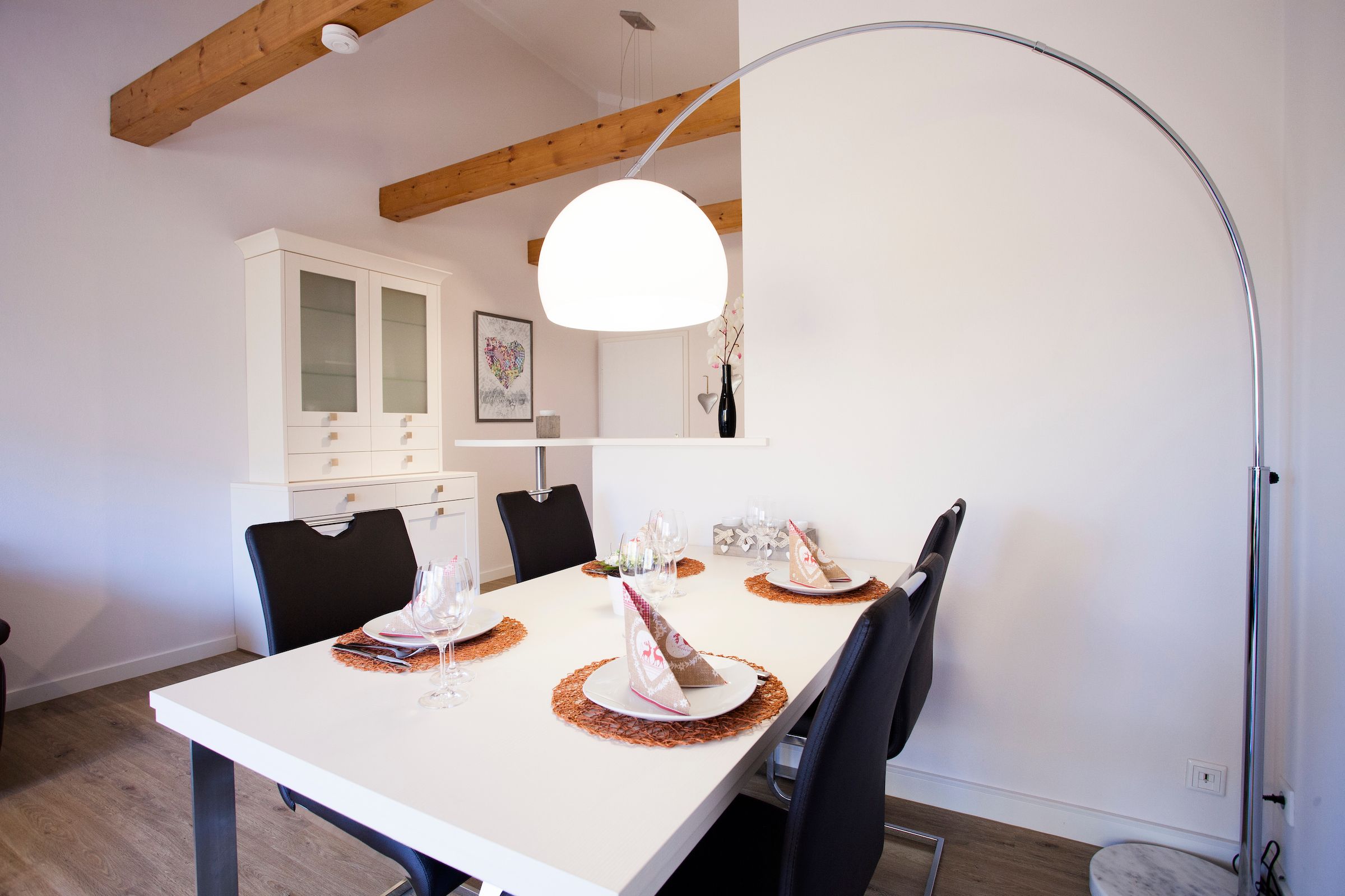 Stehlampe im Essbereich und eine weiße Vitrine in Ferienwohnung in Garmisch-Partenkirchen