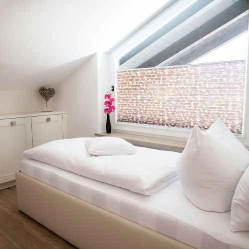 Einzelbett mit einer angebrachten Lampe in Ferienwohnung in Garmisch-Partenkirchen