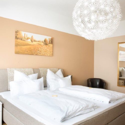 Doppelbett und Bild in Ferienwohnung in Garmisch-Partenkirchen