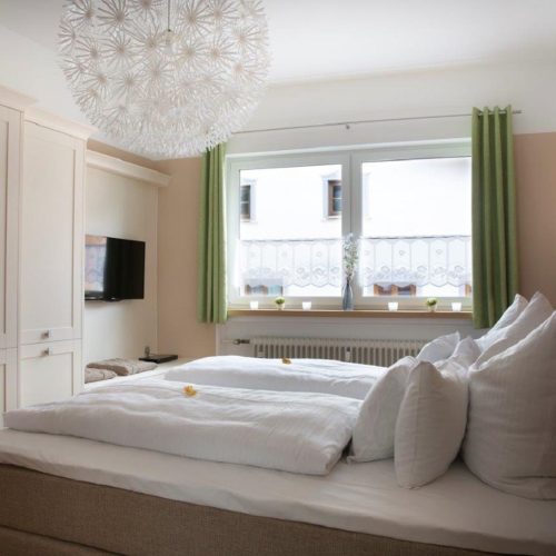 Doppelbett mit Fernseher und Kleiderschrak in Ferienwohnung in Garmisch-Partenkirchen