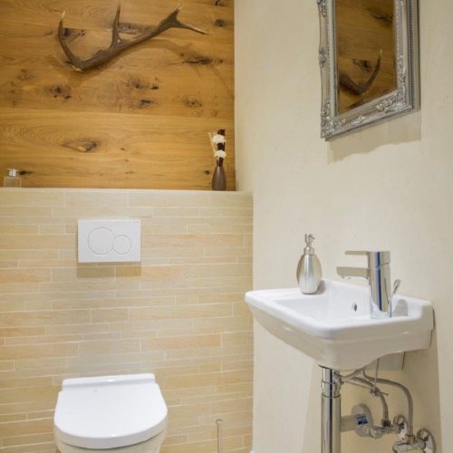 Badezimmer mit Spiegel und Toilette in Ferienwohnung in Garmisch-Partenkirchen