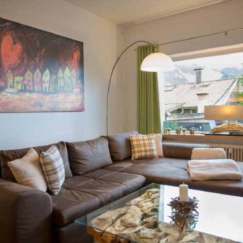 Wohnzimmer mit Stehlampe und Sofa in Ferienwohnung in Garmisch-Partenkirchen