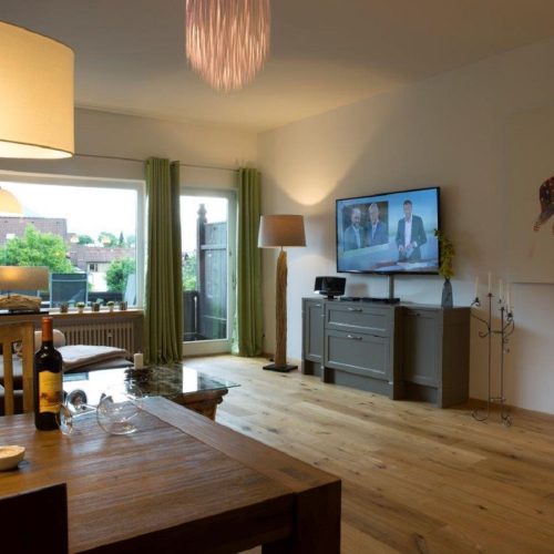 Esszimmer mit Fernseher und Bild von Hirsch in Ferienwohnung in Garmisch-Partenkirchen