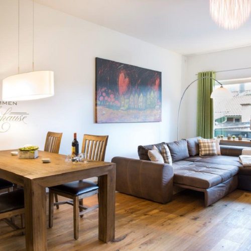 Esszimmer und Fernseher mit Sofa in Ferienwohnung in Garmisch-Partenkirchen