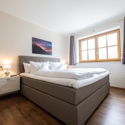 Doppelbett mit Fenster in Ferienwohnung in Garmisch-Partenkirchen