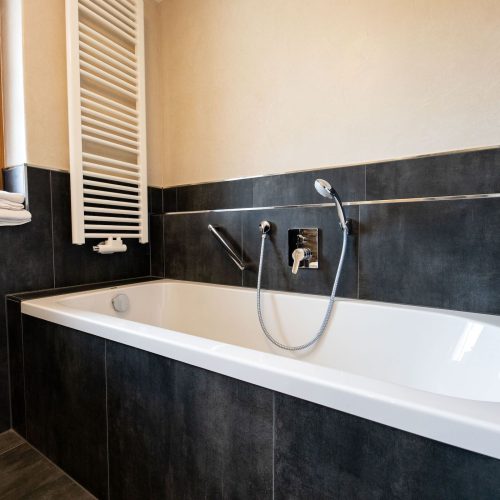 Badewanne mit schwarzen Fliesen in Ferienwohnung in Garmisch-Partenkirchen