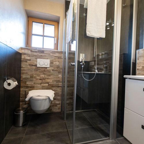 Badezimmer mit dunklen Fliesen in Ferienwohnung in Garmisch-Partenkirchen