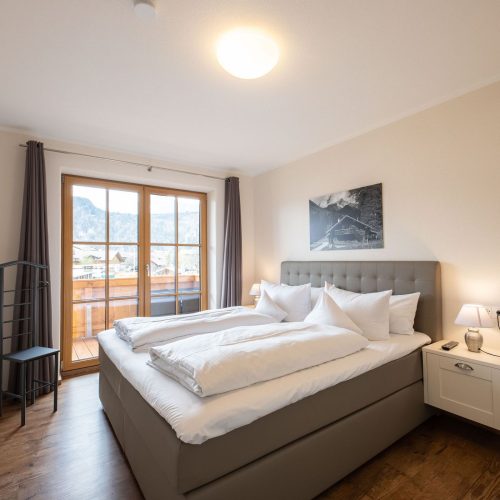 Doppelbett mit Nachttisch in Ferienwohnung in Garmisch-Partenkirchen