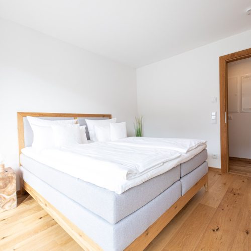 Doppelbett mit viereckigem Nachtschrank in Ferienwohnung in Garmisch-Partenkirchen