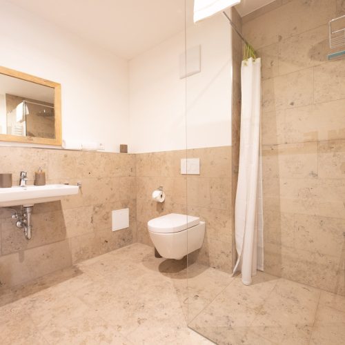 Dusche mit weißem Vorhang in Ferienwohnung in Garmisch-Partenkirchen