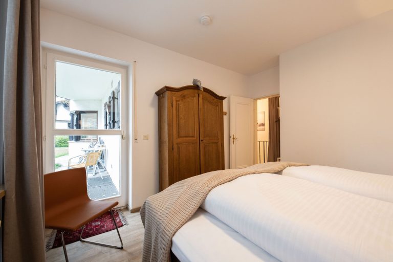 Doppelbett und Stuhl in Ferienwohnung in Garmisch-Partenkirchen