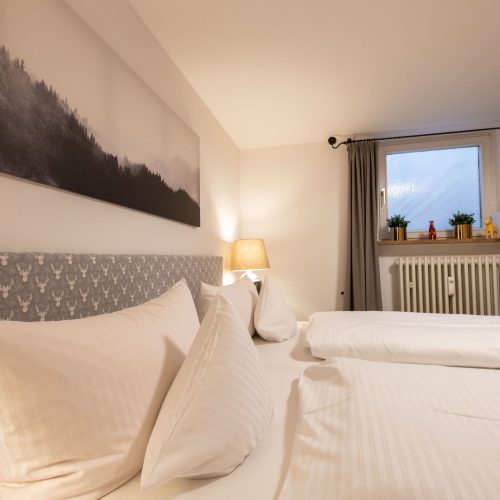 Doppelbett und schwarz-weiß Bild in Ferienwohnung in Garmisch-Partenkirchen