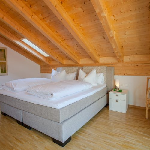 Doppelbett mit Dachfenster in Ferienwohnung in Garmisch-Partenkirchen