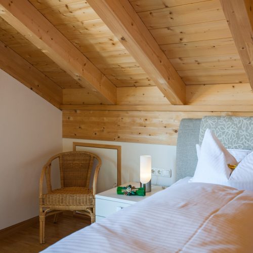 Einzelbett mit Sitzmöglichkeit und Nachttisch in Ferienwohnung in Garmisch-Partenkirchen