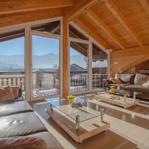 Wohnzimmer mit Couchtisch und Fensterwand in Ferienwohnung in Garmisch-Partenkirchen