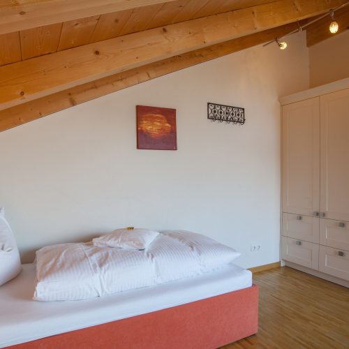 Einzelbett und weißer Kleiderschrank in Ferienwohnung in Garmisch-Partenkirchen