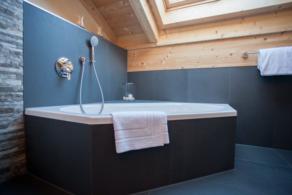Badewanne und schwarze Fliesen in Ferienwohnung in Garmisch-Partenkirchen