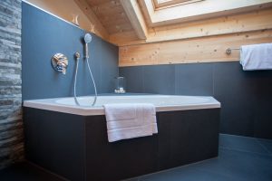 Badewanne und schwarze Fliesen in Ferienwohnung in Garmisch-Partenkirchen