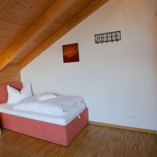 Einzelbett mit Nachttisch in Ferienwohnung in Garmisch-Partenkirchen