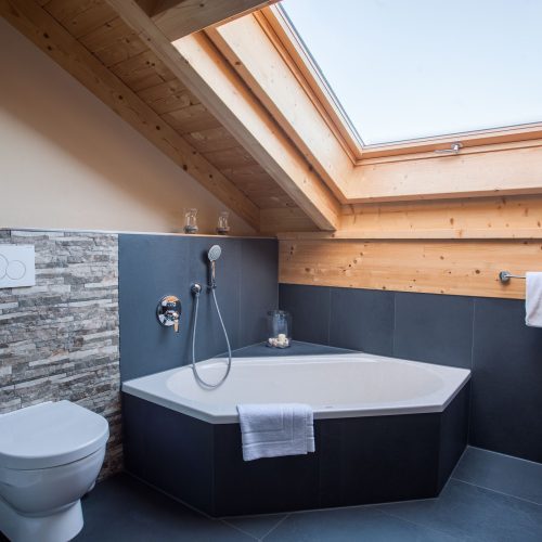 Badewanne und schwarze Fliesen in Ferienwohnung in Garmisch-Partenkirchen