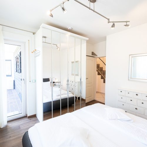 Doppelbett mit Spiegel und Kleiderschrank in Ferienwohnung in Garmisch-Partenkirchen