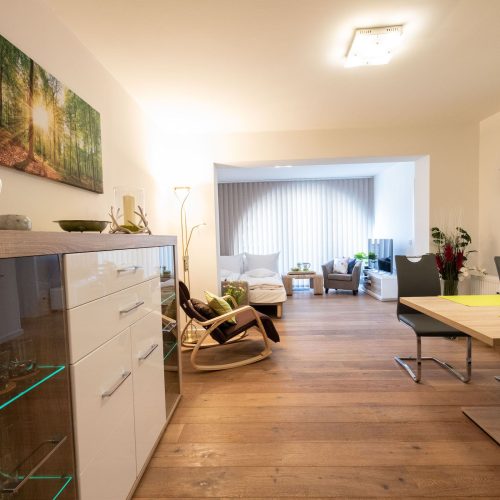 Offener Wohnbereich mit Esstisch und Schlafsofa mit Fernsehen in Ferienwohnung in Garmisch-Partenkirchen