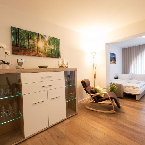 Wohnbereich mit Sitzmöglichkeiten und einer Vitrine in Ferienwohnung in Garmisch-Partenkirchen