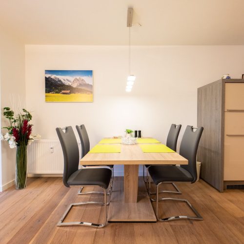 Essbereich mit einem Holztisch und grauen Stühlen in Ferienwohnung in Garmisch-Partenkirchen