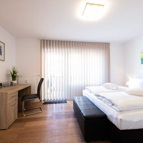 schwarzes Doppelbettzimmer mit Vorhängen in Ferienwohnung in Garmisch-Partenkirchen