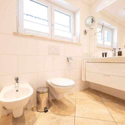 Badezimmer mit großem Waschbecken und großem Spiegel in Ferienwohnung in Garmisch-Partenkirchen