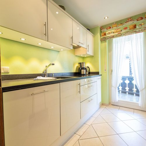 Hellgrüne Wand und weiße Küche in Ferienwohnung in Garmisch-Partenkirchen
