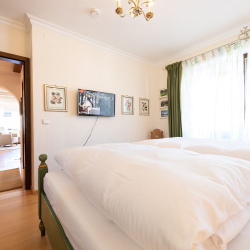 Doppelbett in grün und Gardienen in Ferienwohnung in Garmisch-Partenkirchen