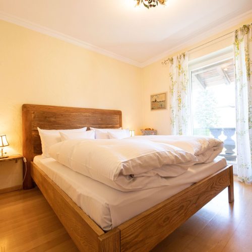 Doppelbett mit Holzrahmen in Ferienwohnung in Garmisch-Partenkirchen