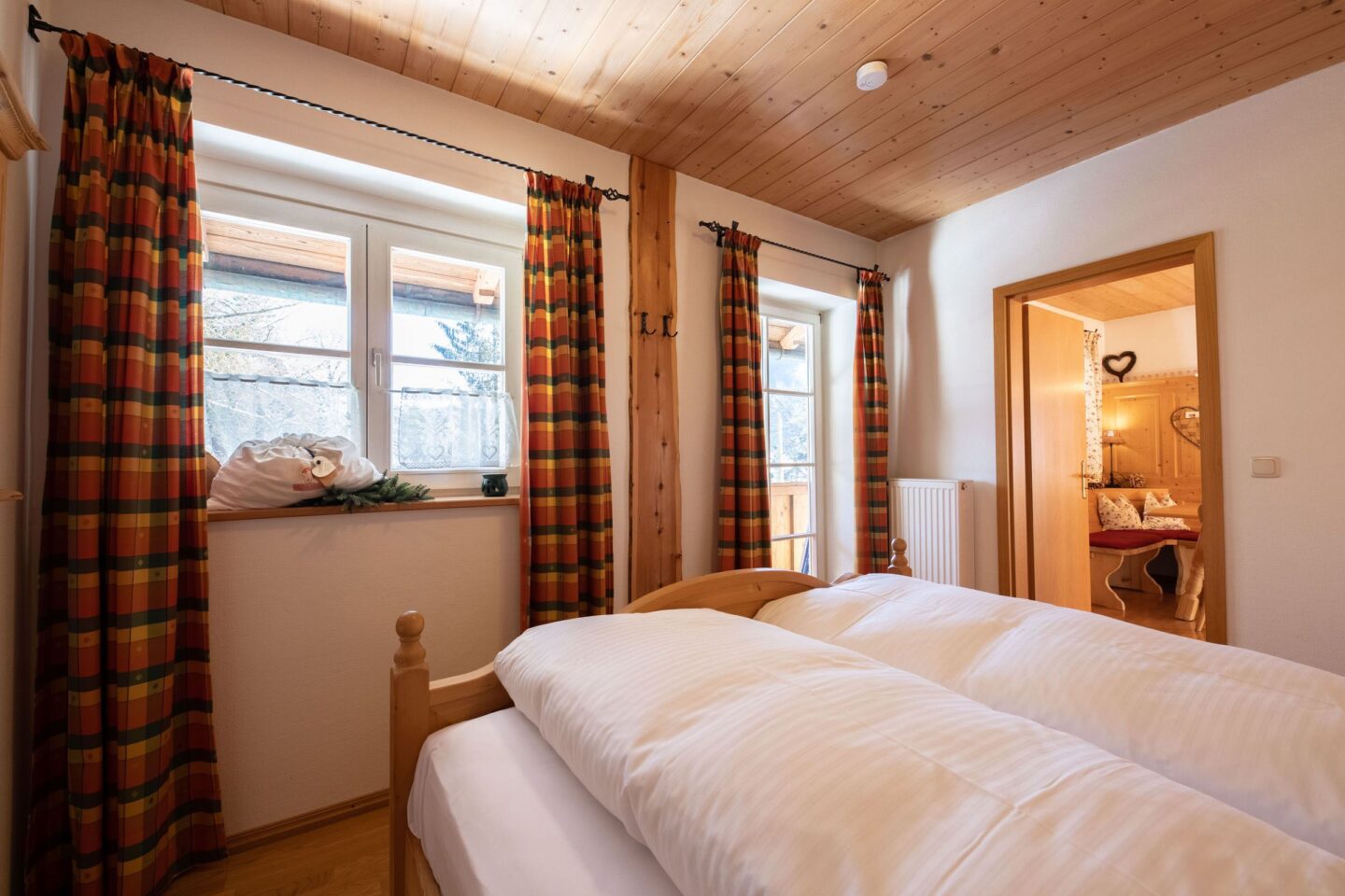 Doppelbett und Fenster in Ferienwohnung in Garmisch-Partenkirchen